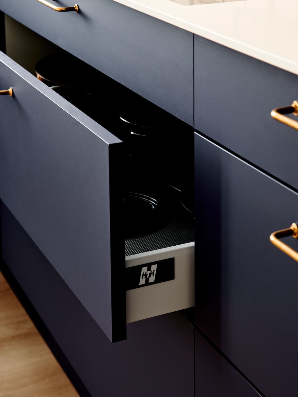 Blue kitchen cabinets with open drawer and gold handles | HTH