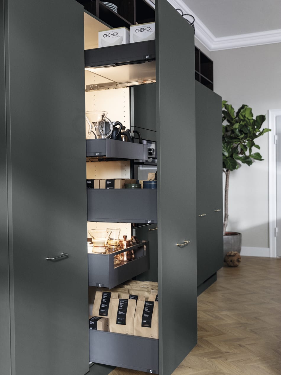 Dark green kitchen cabinets with pull-out shelves and silver handles. Model Base | HTH