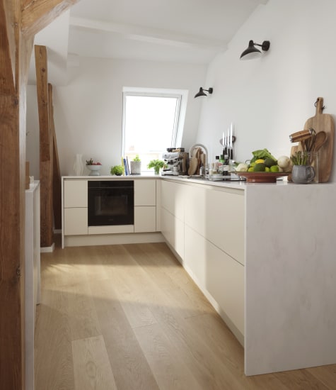 White kitchen cabinets with light wood flooring and wood beam detail | HTH