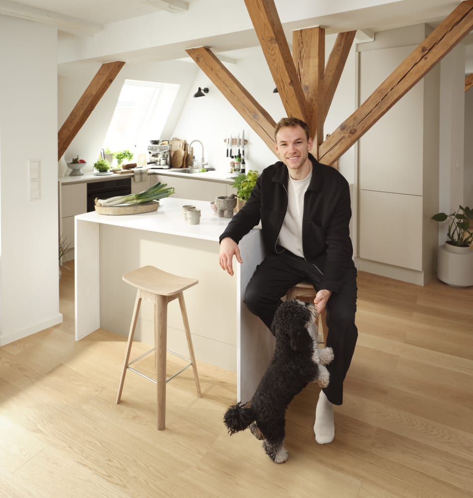 Person in kitchen with white cabinets and wood countertop | HTH