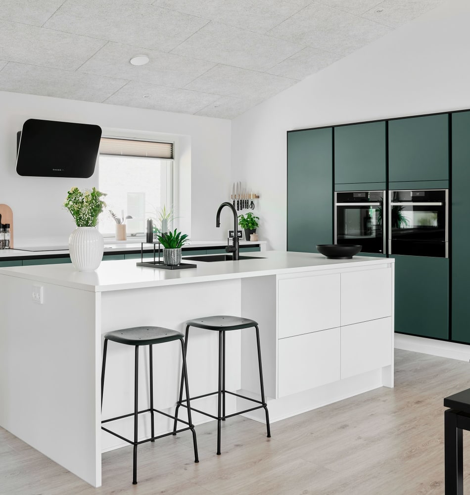 White kitchen island with green cabinets and wood floor | HTH