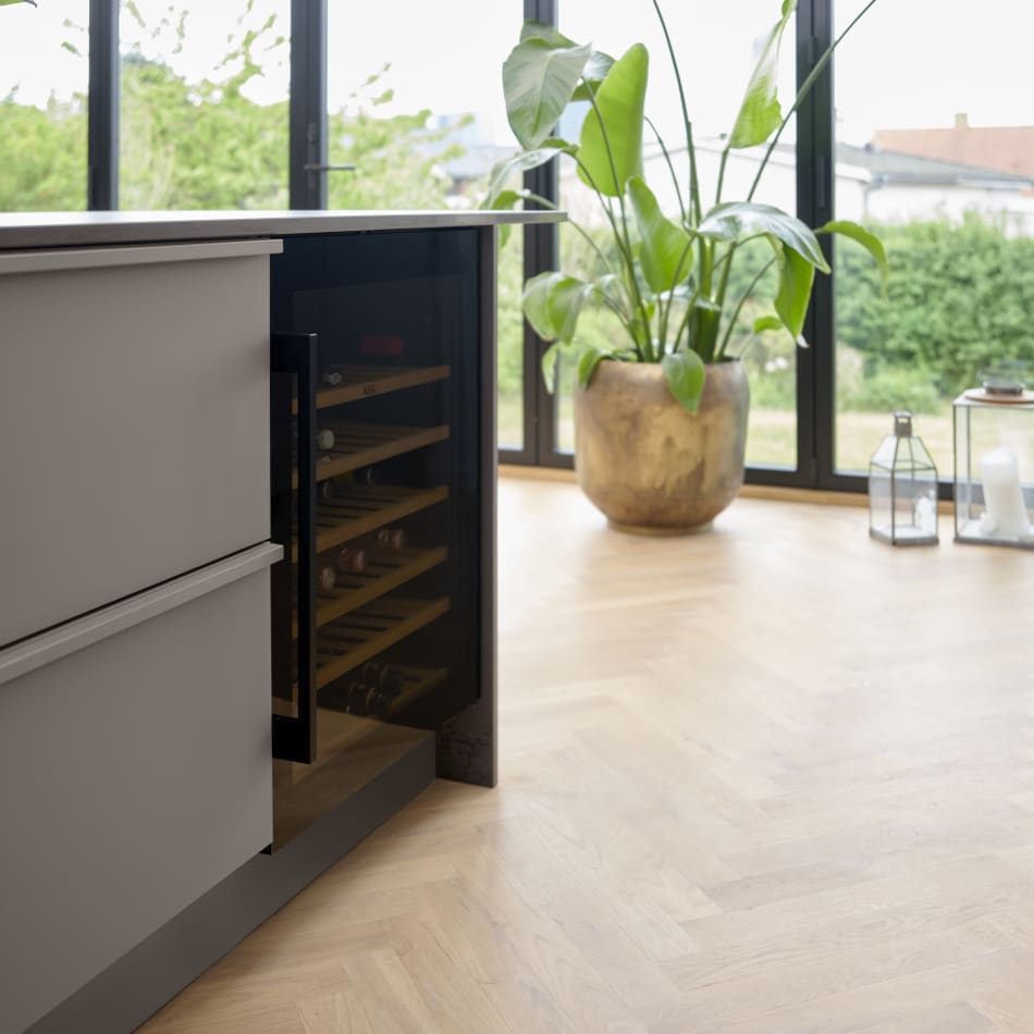 Gray kitchen cabinets with integrated wine cooler, wooden floor | HTH