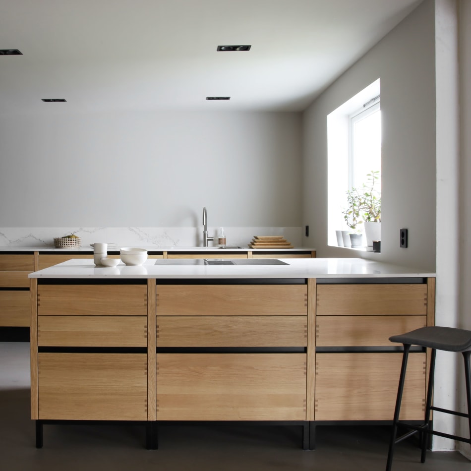 Wooden kitchen cabinets with white countertop and black accents | HTH