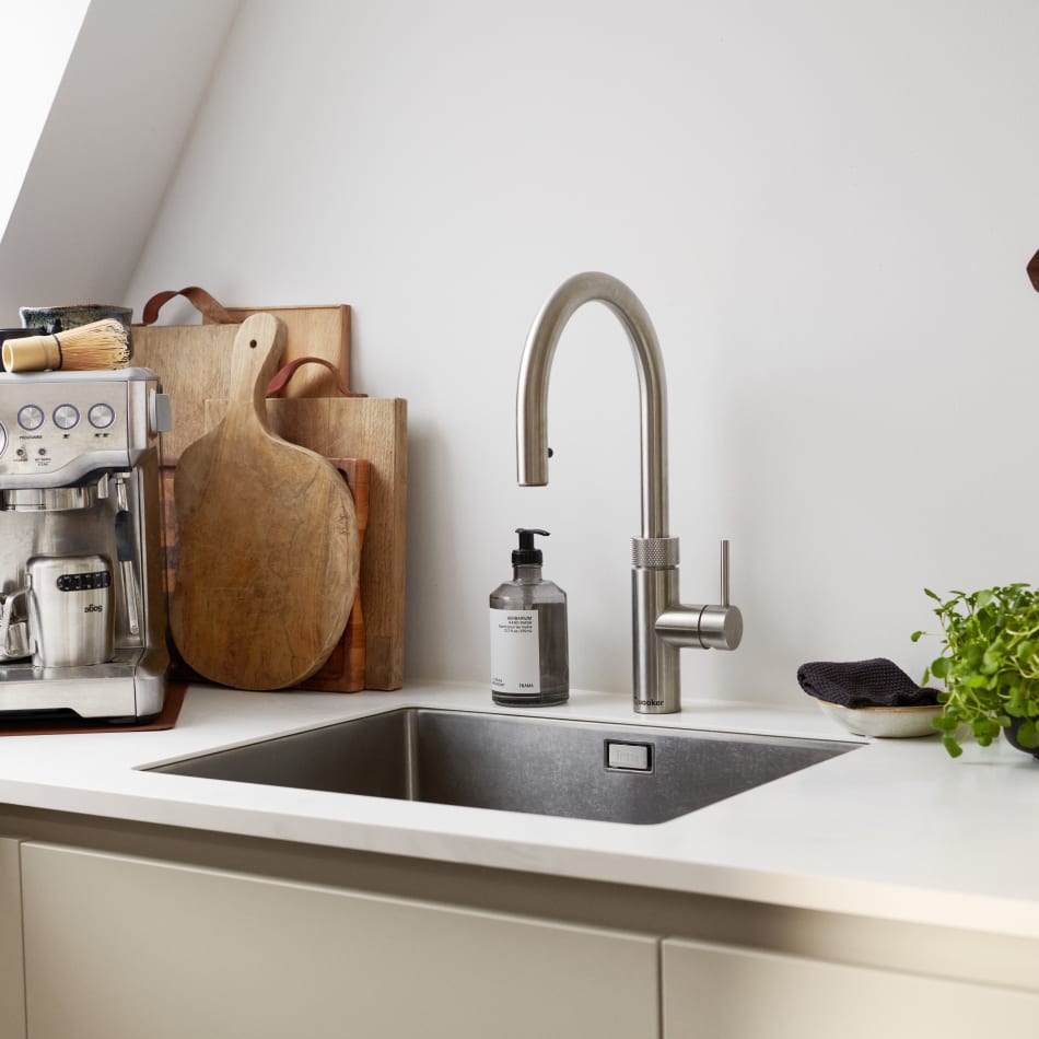 White kitchen with beige cabinets and wood cutting boards near sink | HTH
