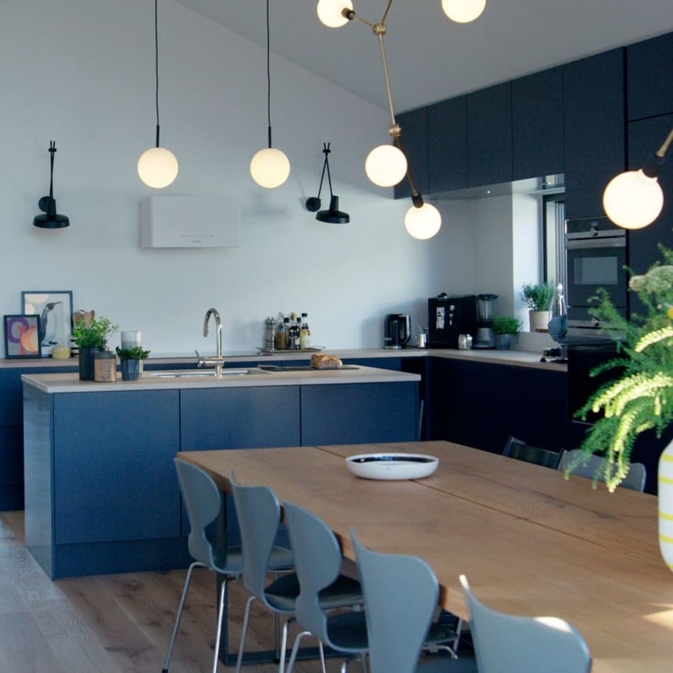 Dark blue kitchen cabinets and wood kitchen island with chairs and table | HTH