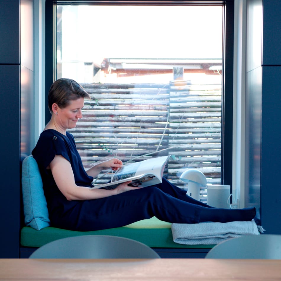 a person is sitting on a window sill reading a book