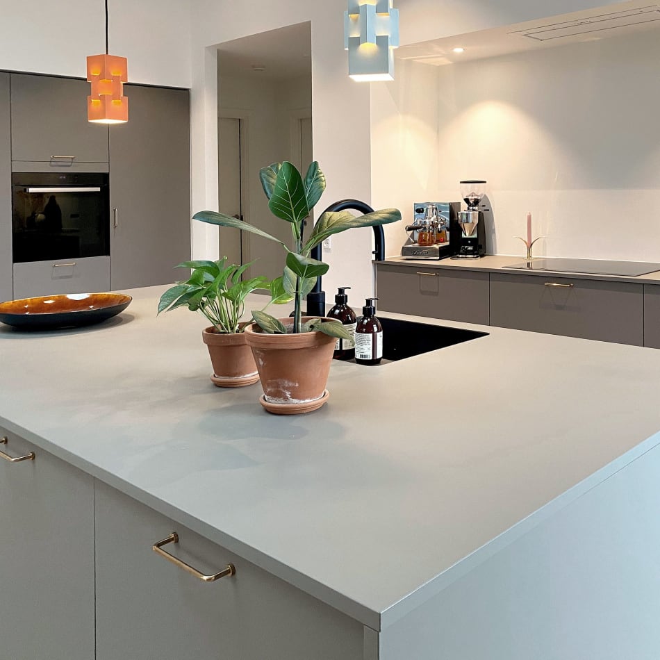 Grå køkkenø med skabe og integreret vask, beige bordplade og planter | HTH