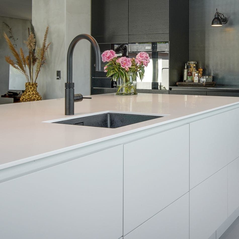 White kitchen island with sink and dark cabinets in background | HTH