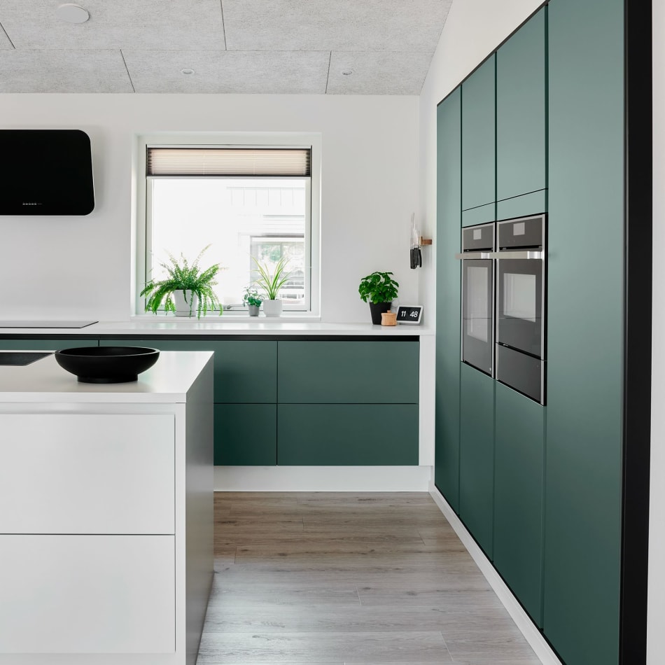 Green kitchen cabinets and white kitchen island with wood floor | HTH