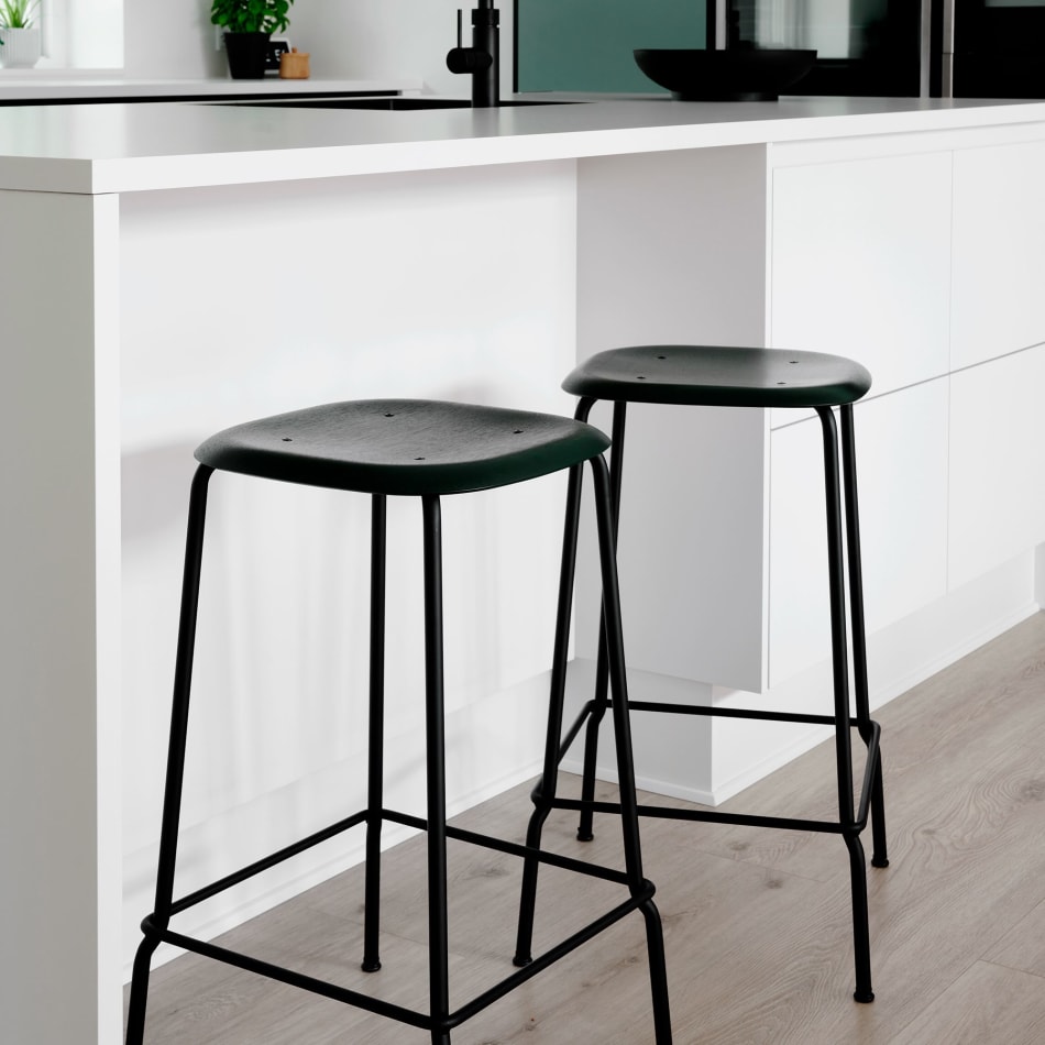 White kitchen island with black stools and green cabinets | HTH