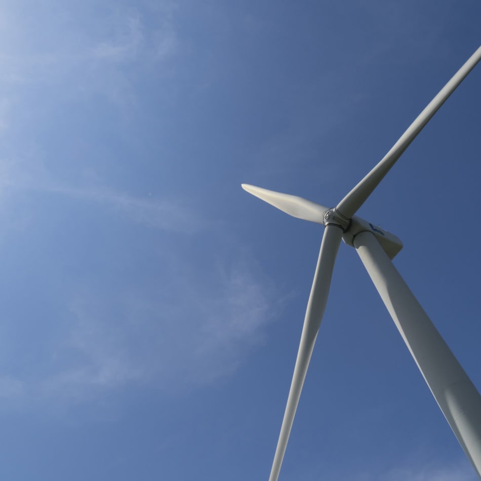 a wind turbine with a blue sky in the background