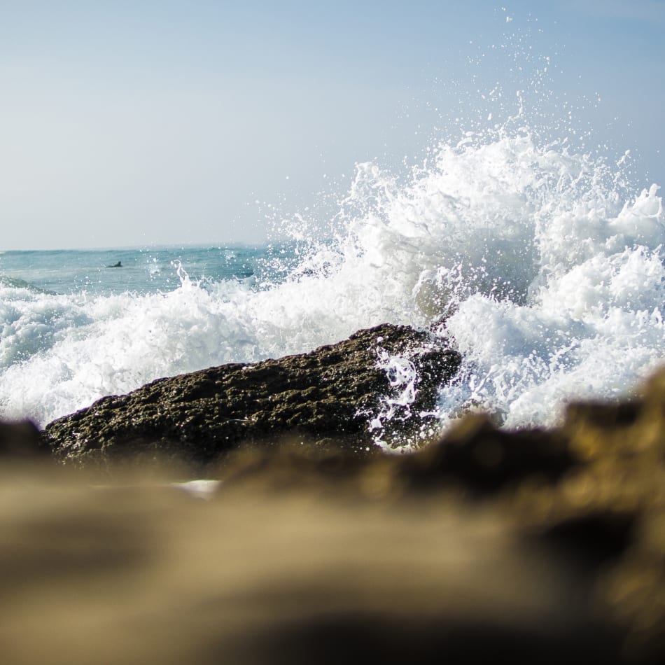 the waves are crashing against the rocks on the beach