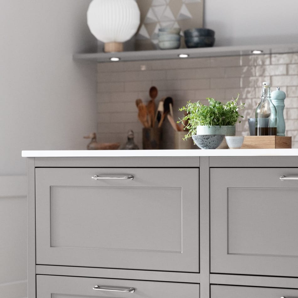 Gray kitchen cabinets with white countertop and silver handles. Model Art | HTH