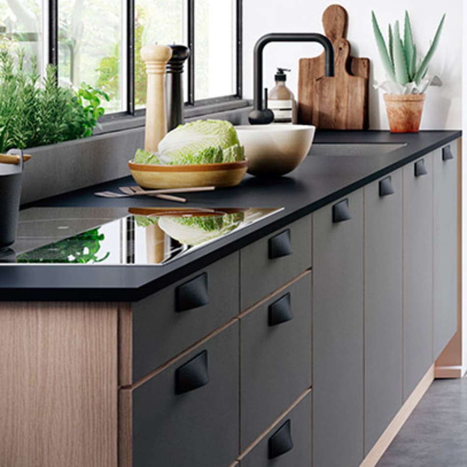 Dark sand laminate kitchen with black countertop and handles, featuring a black faucet. Focus Laminate | HTH