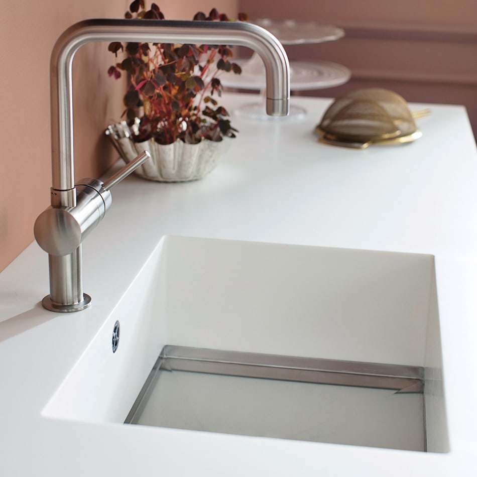 White countertop with integrated sink and stainless steel faucet. Harmony Dark | HTH