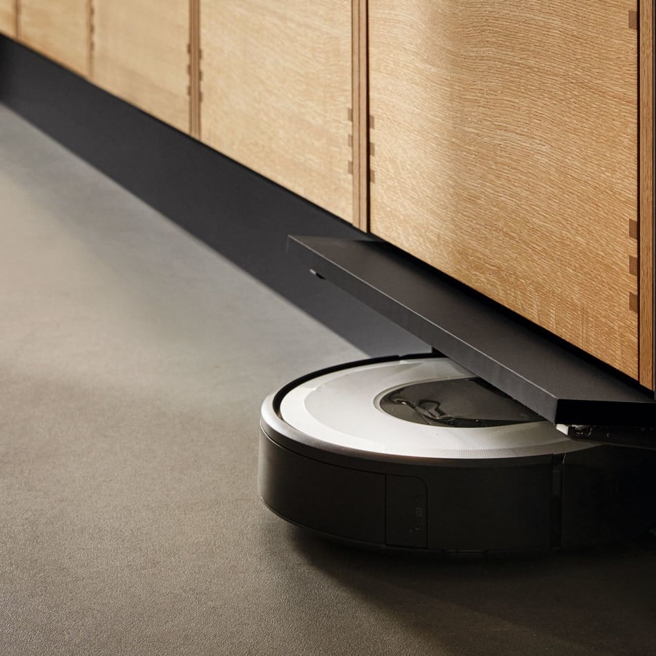 Wooden kitchen cabinets with black base and a robotic vacuum on the floor. Nordic Creation | HTH