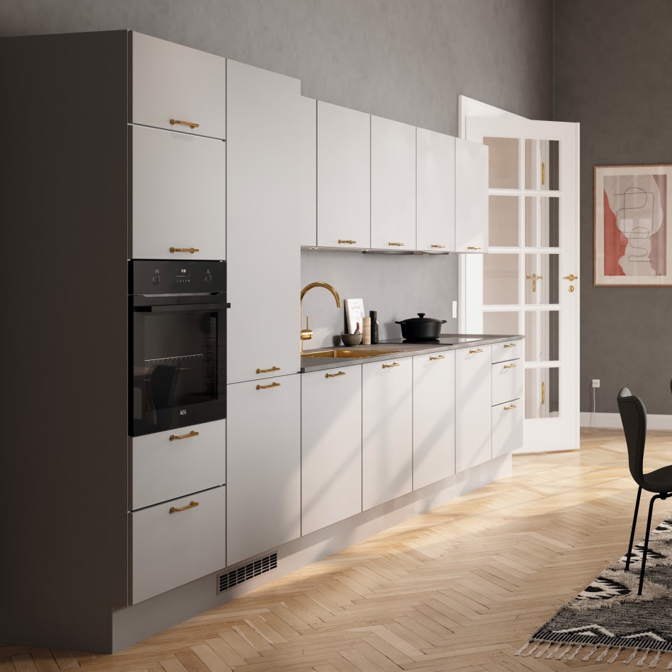 Gray kitchen cabinets with gold handles and a black countertop. Grey Kitchen | HTH