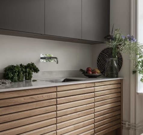 Wooden kitchen cabinets with gray upper cabinets and white countertop | HTH