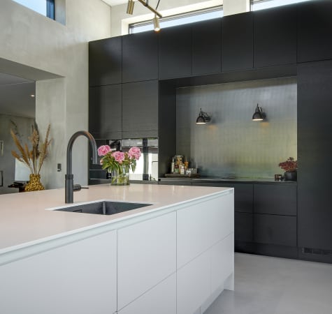 White kitchen island with black cabinets and integrated sink | HTH