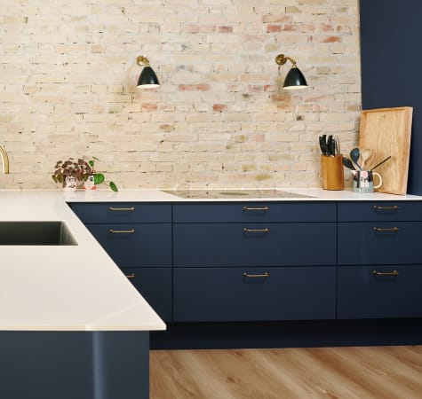 Navy blue kitchen cabinets with white countertop and wood kitchen island countertop | HTH