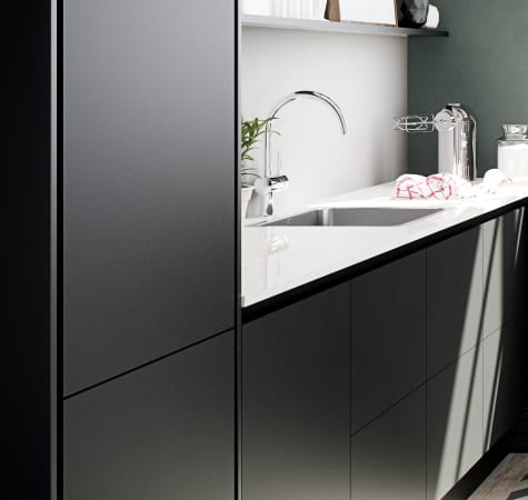 Black kitchen cabinets with white countertop and silver faucet. Focus Laminate | HTH