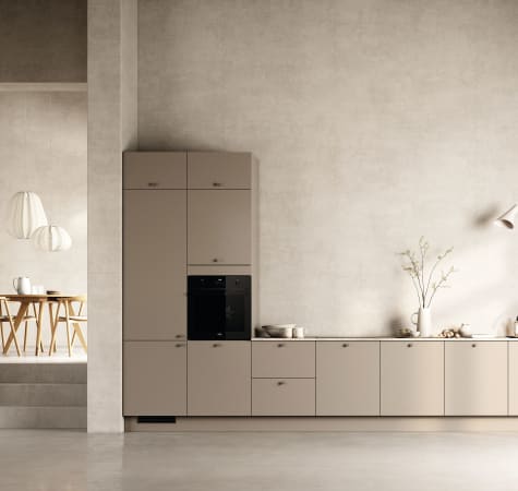 Beige kitchen cabinets with black oven and minimalist design. Stockholm Kitchen | HTH