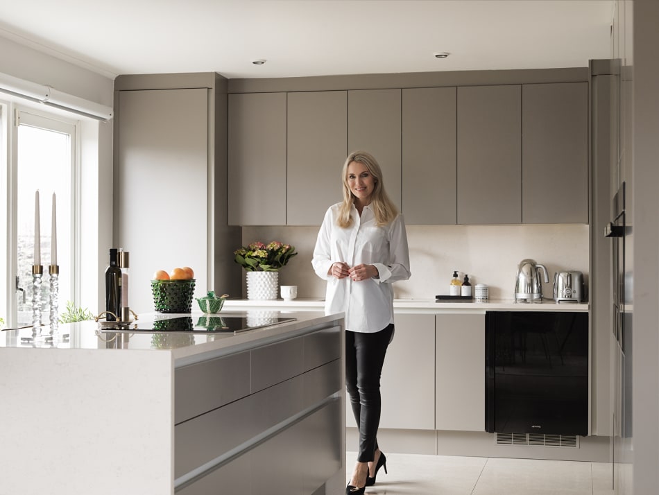 Person in a kitchen with gray cabinets and a white kitchen island | HTH