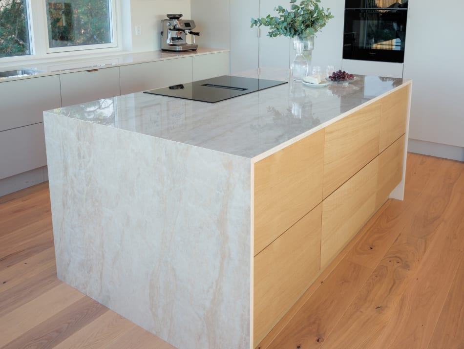 Kitchen island with light wood drawers and marble texture countertop | HTH