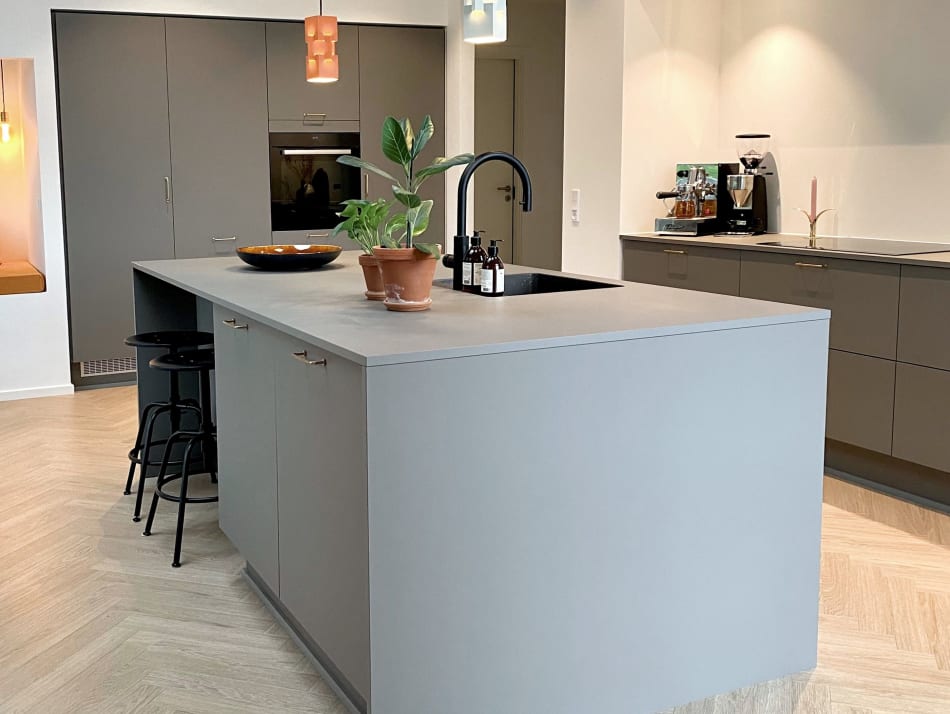 Gray kitchen cabinetry and island featuring a matte finish and integrated sink | HTH