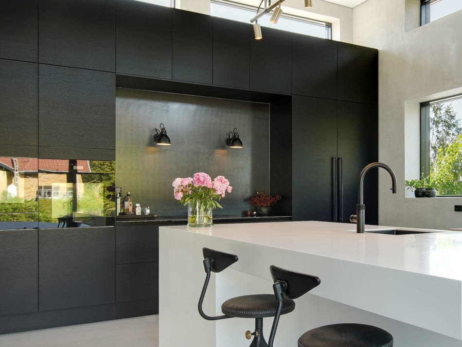 Black kitchen cabinets with white kitchen island and two black stools | HTH