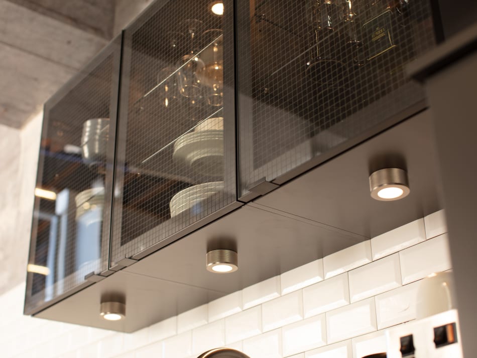 Black kitchen cabinets with glass doors and white tile backsplash | HTH