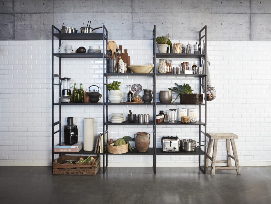 Black metal shelving unit with kitchen items against white tile wall | HTH