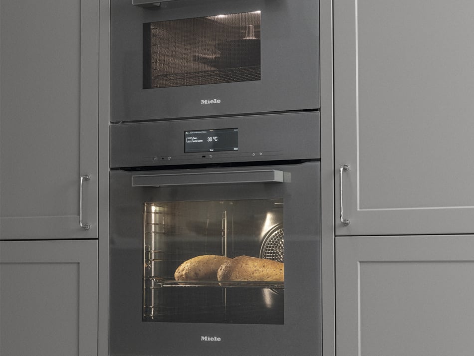 Gray kitchen cabinets with built-in Miele ovens. Model Art | HTH