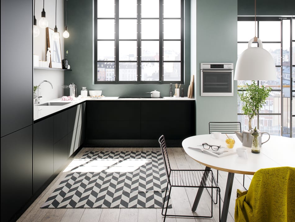 Black kitchen cabinets with white countertop and green walls. Focus Laminate | HTH