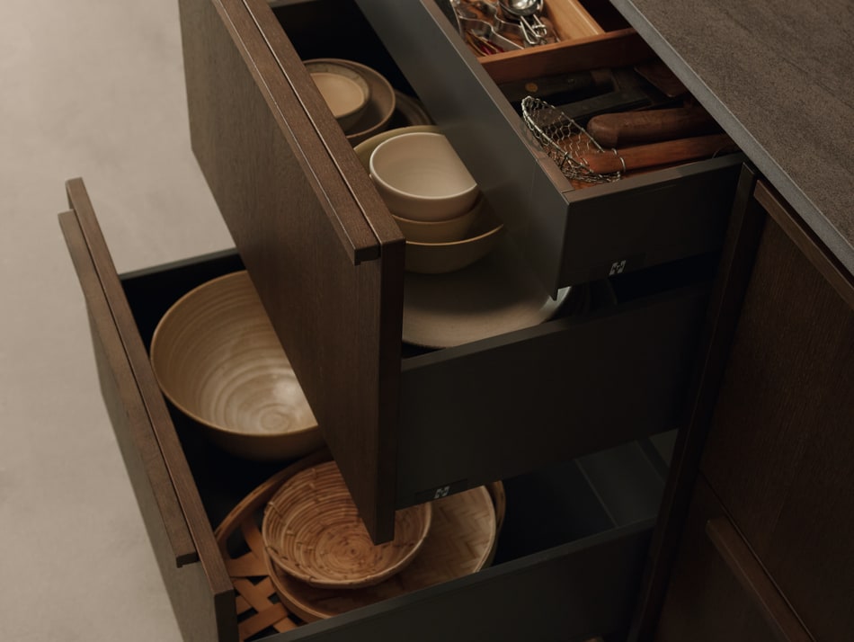 Dark wood kitchen drawers with open compartments and a dark countertop. Nordic Atmosphere | HTH