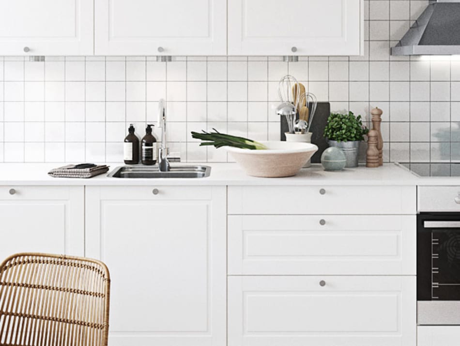 White kitchen cabinets with silver handles and a tiled backsplash. Sense Kitchen | HTH