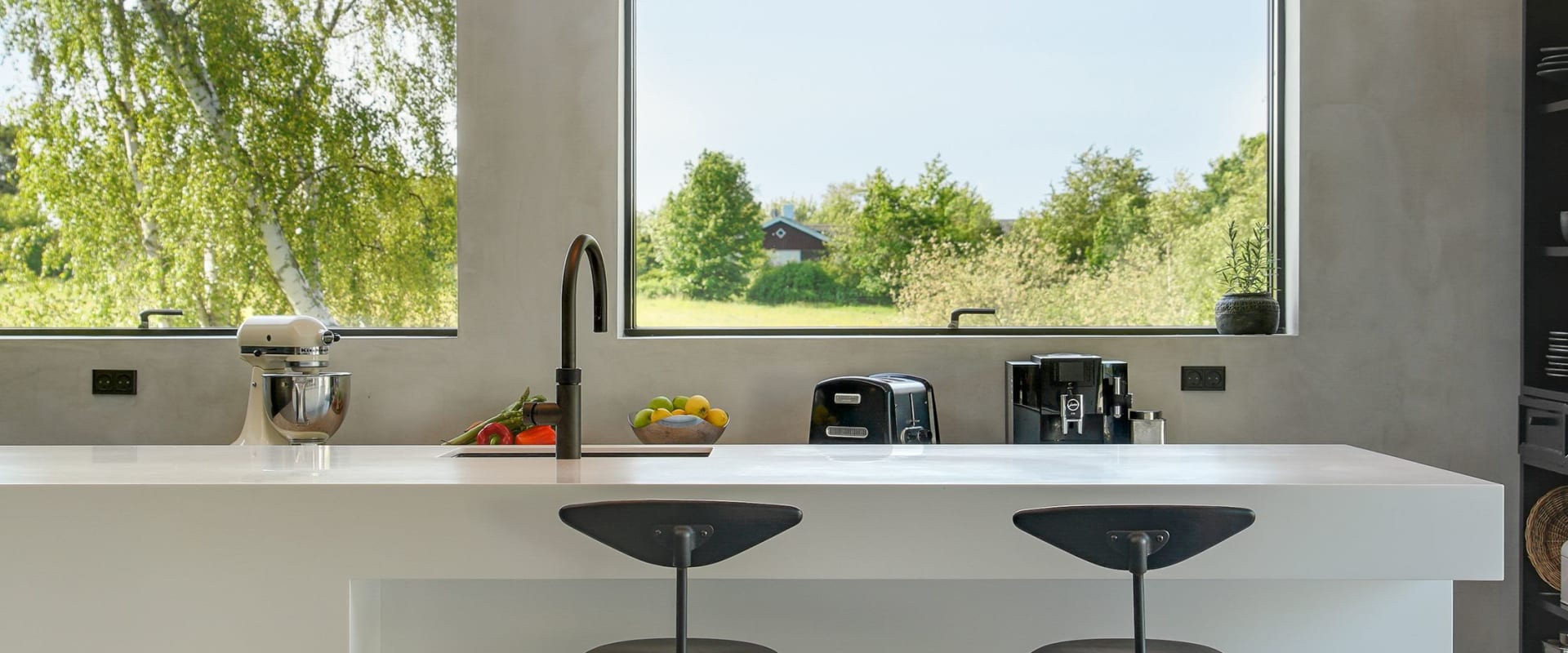 White kitchen island with black stools and faucet, large windows in background | HTH