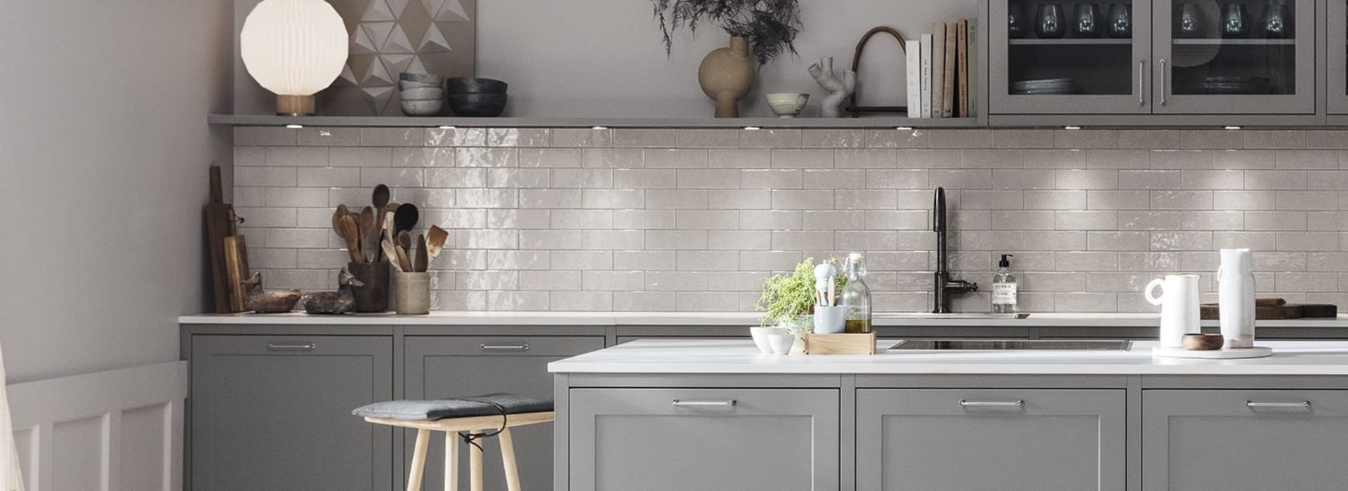 Gray kitchen with kitchen island, white countertop, and pendant lights. Model Art | HTH