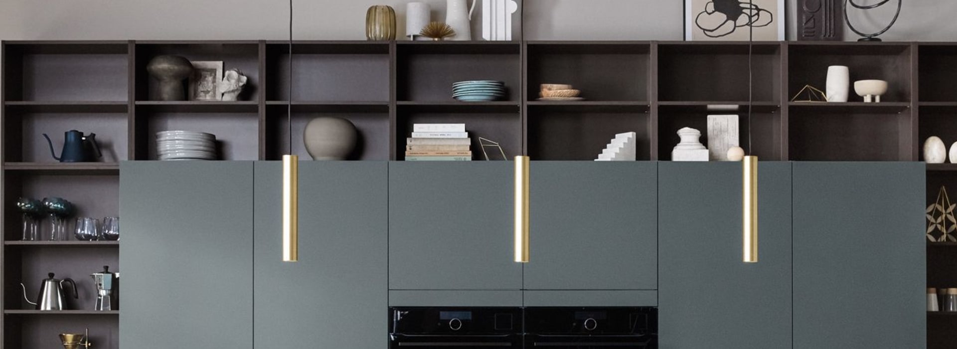 Dark green kitchen cabinets with black appliances and wood-paneled kitchen island. Nordic Spirit | HTH
