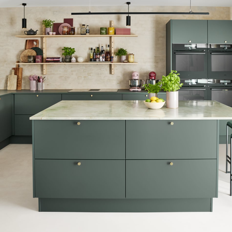 Green kitchen cabinets with kitchen island, marble texture countertop, and built-in ovens | HTH