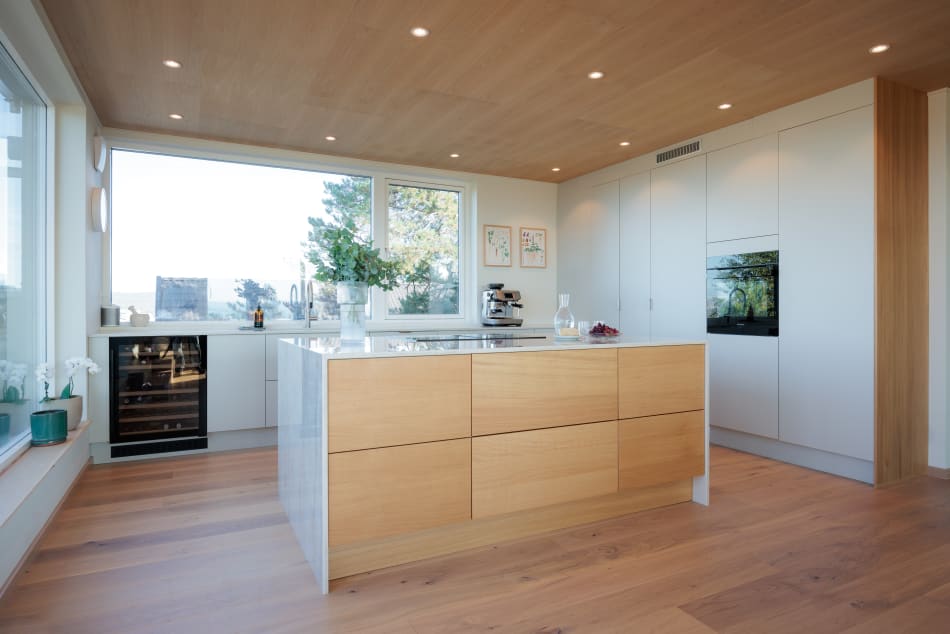 Wooden kitchen island with white cabinets and wood floor | HTH