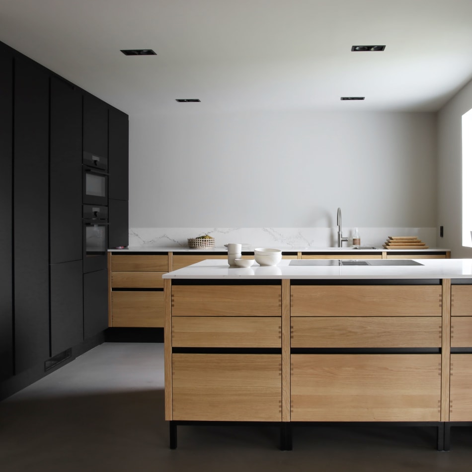 Wooden kitchen cabinets with black accents and white countertop | HTH