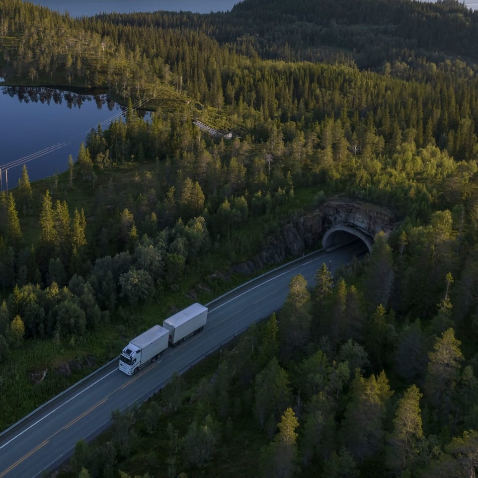 ilmakuva kuorma-autosta ajamassa tietä pitkin metsässä