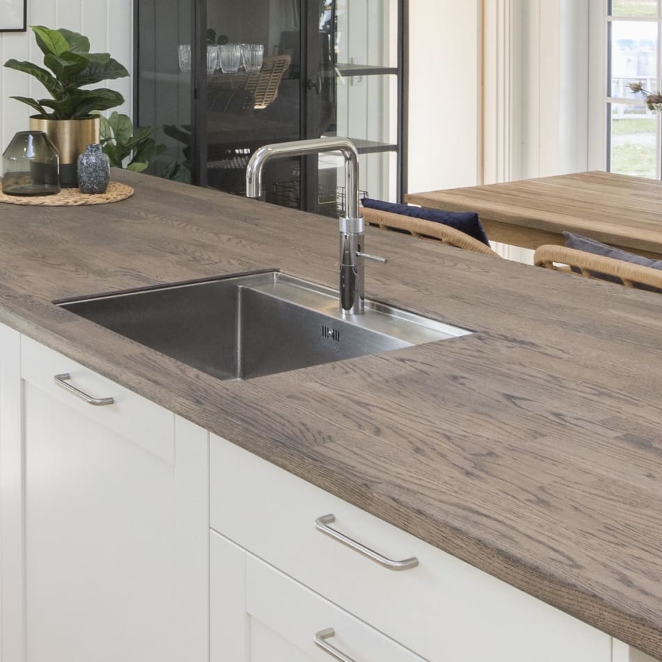 White kitchen cabinets with wood countertop and stainless steel faucet. Model Art | HTH