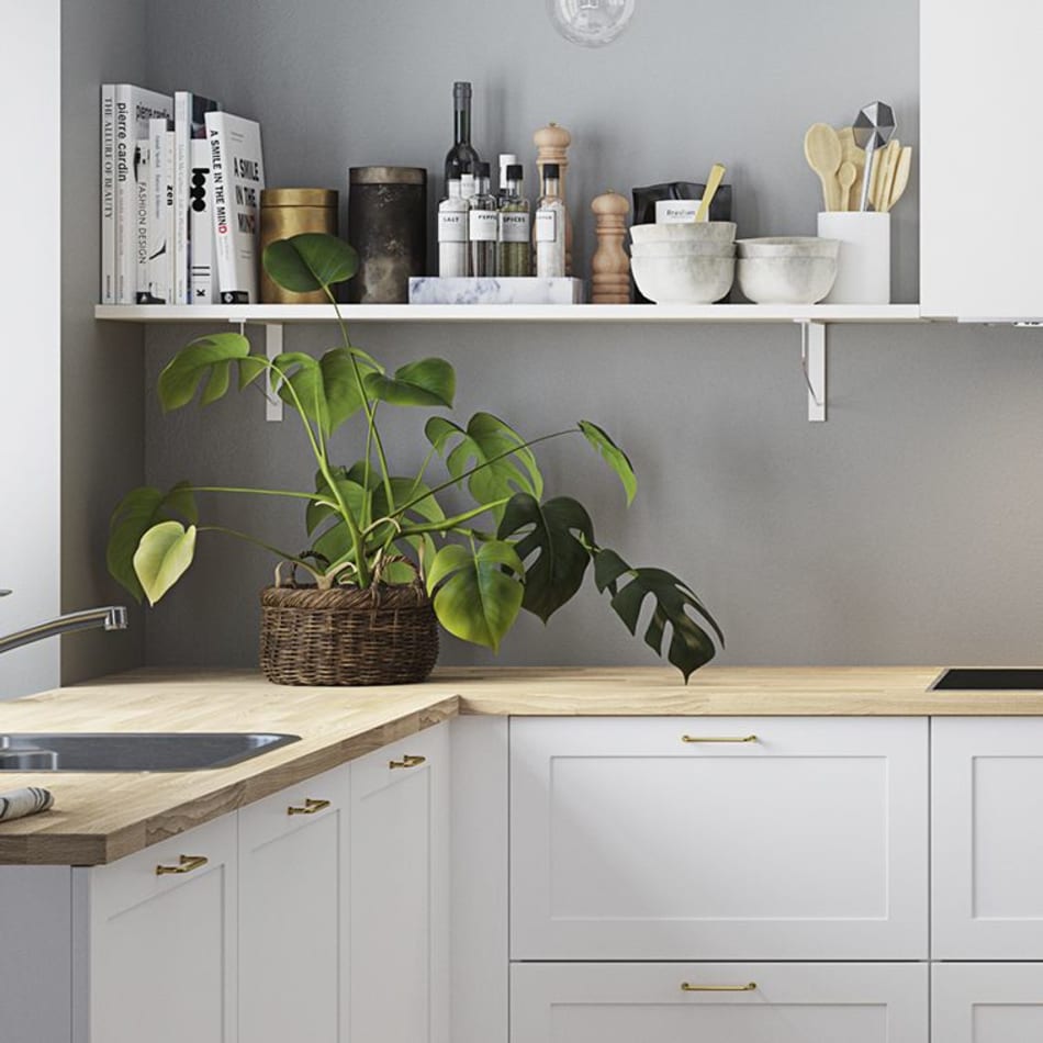 White kitchen with light wood countertop and gold handles. Model Art | HTH