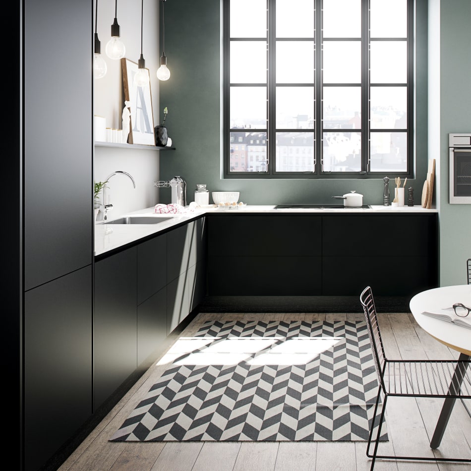 Black kitchen cabinets with white countertop and black-and-white patterned floor. Focus Laminate | HTH