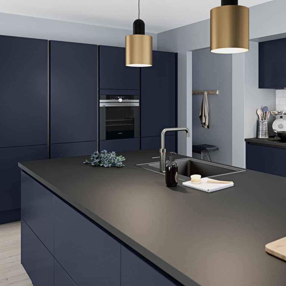 Navy blue kitchen with black countertop and stainless steel faucet. Focus | HTH