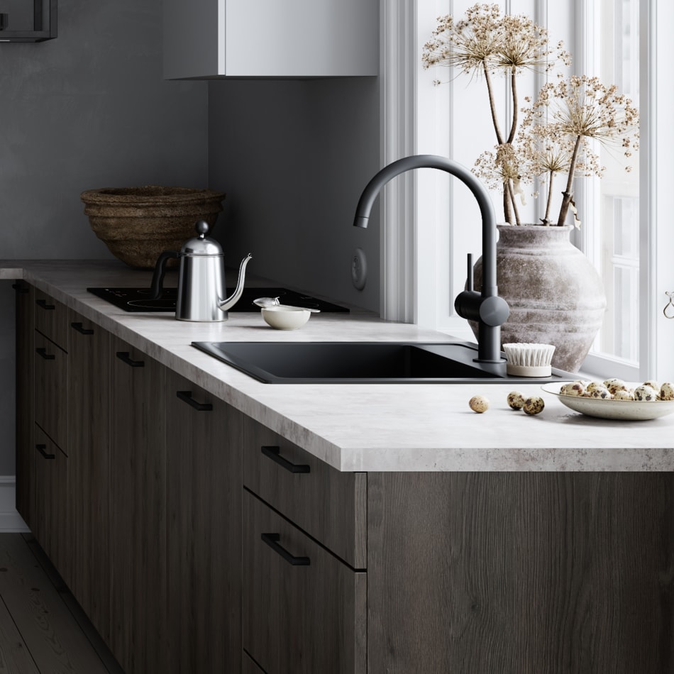 Dark wood kitchen cabinets with light countertop and black faucet. Mood | HTH