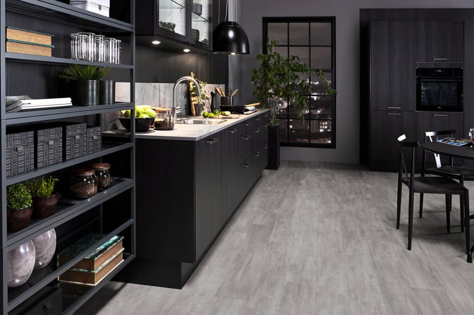 Black kitchen cabinets with light gray countertop and dark appliances. One Kitchen | HTH